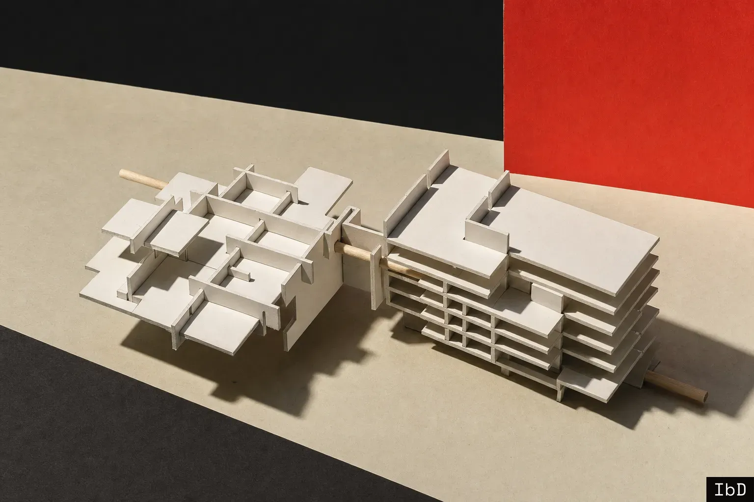 A white card study model of two notched architectural components sliding together to complete a unified structure on a neutral surface.